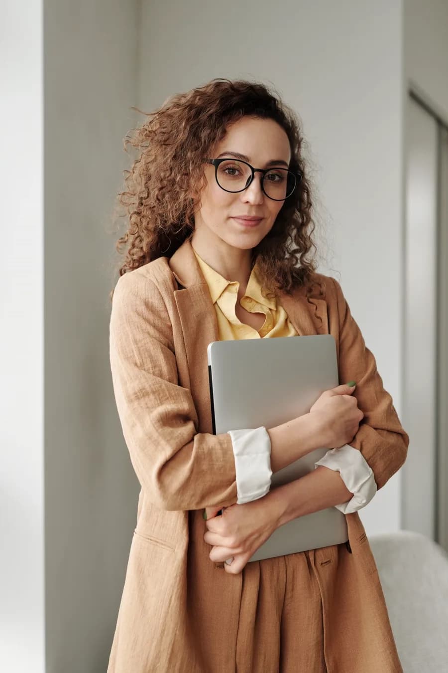A professional carrying her laptop in the office